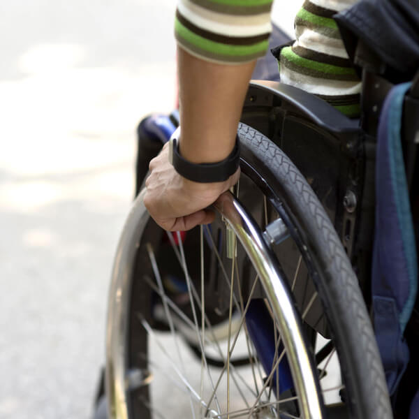 Carrozzine Elettriche per Disabili Milano - Vista ravvicinata di una carrozzina con una mano sulla ruota